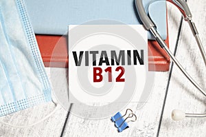 Stethoscope and white card with vitamin b12 text on notebook