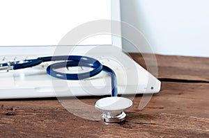 stethoscope with white laptop computer on desk for working