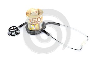 Stethoscope wrapped around roll of paper euro notes