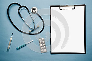 Stethoscope, writing board, blue background