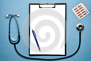 Stethoscope, writing board, pen and pills