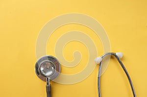 Stethoscope on a yellow background.Concept of health care
