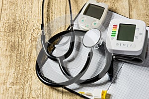 Stethoskope on wooden desk with blood pressure measurement copy