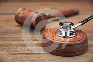 Stetoscope and Real Judges Gavel On Brown Wooden Background photo