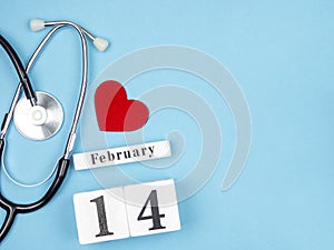 Stetscope, a red heart and a calendar on a blue background. Valentine`s Day