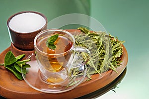 Stevia dry leaves and Stevia sweetener in clayware on mirror background. Stevia have Stevioside Steviol glycosides extracted photo