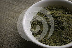 Stevia powder in white plate on wooden background