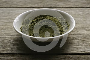 Stevia powder in white plate on wooden background