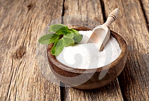 Stevia rebaudiana, sweet leaf sugar substitute isolated in wooden bowl on wooden background