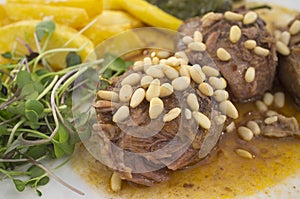 Stew cheek pieces of iberian topped with pine nuts and corn salad
