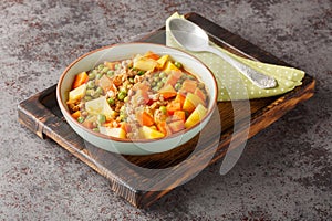 Stew of minced meat, green peas, carrots and potatoes with spicy tomato sauce close-up in a bowl. Horizontal