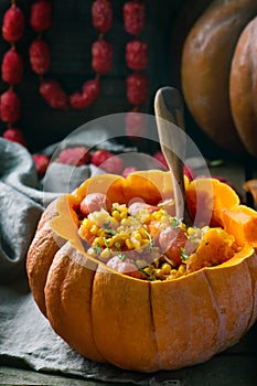 Stew from pumpkin with salami sausages in the whole pumpkin