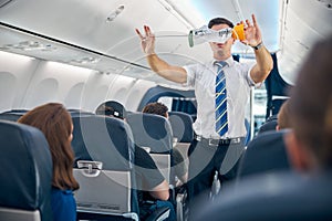 Steward demonstrating safety procedure prior to commercial airline flight took off photo