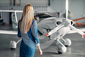 Stewardess against turboprop airplane in hangar