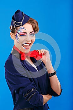 Stewardess with face art winks.