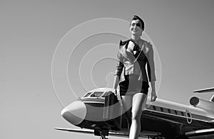 Stewardess. Journey and jet trip. Woman and commercial plane. Portrait of charming stewardess wearing in blue uniform