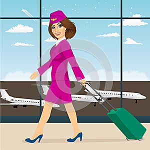 Stewardess with luggage walking through airport terminal