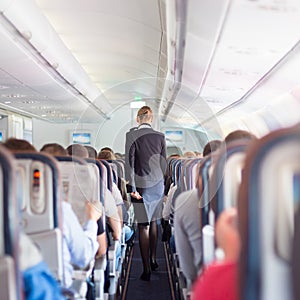 Stewardess and passengers on commercial airplane. photo