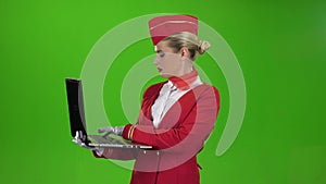 Stewardess prints the text on the laptop. Green screen