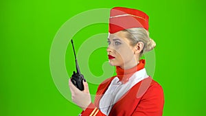 Stewardess speaks on the walkie talkie. Green screen