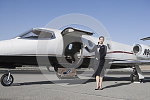 Stewardess Standing By Airplane At Airfield photo