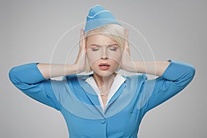 Stewardess in stressful situation. Fright, hysterics, phobia. Gray background