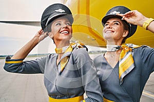 Stewardesses in pilot caps standing at the airdrome