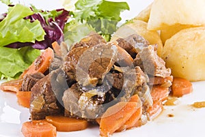 Stewed beef steak with potatoes and salad photo