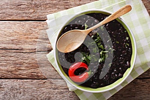 stewed black beans with spices and herbs in a bowl close-up. horizontal top view