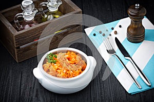 Stewed cabbage bigos on black wooden background