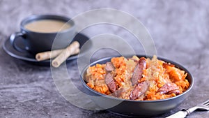 Stewed cabbage with sausages in black plate. horizontal side view