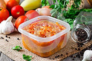 Stewed carrots and onions in a plastic container