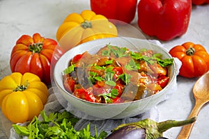 Stewed eggplant, tomato, pepper  preserve  on a concrete background cooking