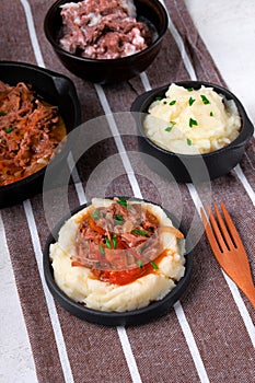 Stewed meat with potato mash served on the plate.