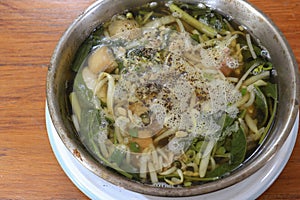 Stewed pork soup with morning glory and bean sprout on wooden table.