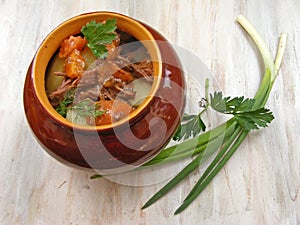 Stewed rabbit with vegetables, Venison Goulash in Copper Pot on Wooden Surface, roasted beef meat with vegetables and herbs in rou