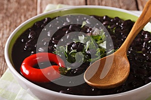 Stewed spicy black beans close up in a bowl. Horizontal