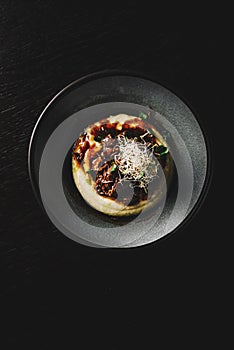 Stewed veal cheeks with mashed potatoes on plate on rustic wooden table