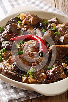 Stewed veal with wild forest mushrooms in a wine sauce close-up. vertical