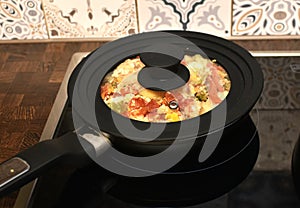 stewed vegetables with eggs in a frying pan with a silicone lid