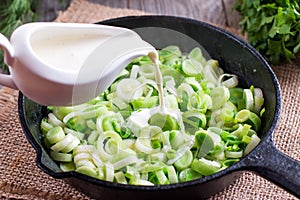 Stewing leek slices in a frying pan with cream