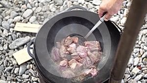 Stewing meat for Uzbek pilaf in a cauldron