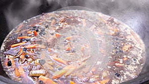 Stewing raisins, meat, carrots and onions in Uzbek pilaf