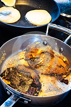 Stewpan with remains while cooking pancakes