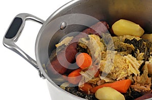 Stewpot with vegetables and sausage close-up