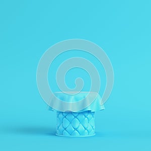 Stiched pedestal covered by fabric on bright blue background in pastel colors