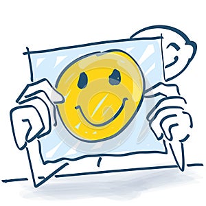 Stick figure behind a note paper and a happy face on it