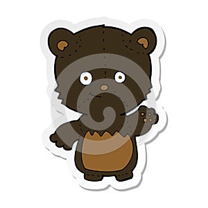 sticker of a cartoon black bearcub waving