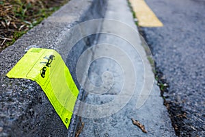 A sticker on the curb of a street warns that a car has been withdrawn and fined by a tow truck for being improperly parked