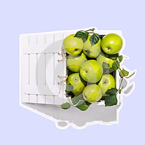 Sticker of fresh green apples in a wooden box on a blue background